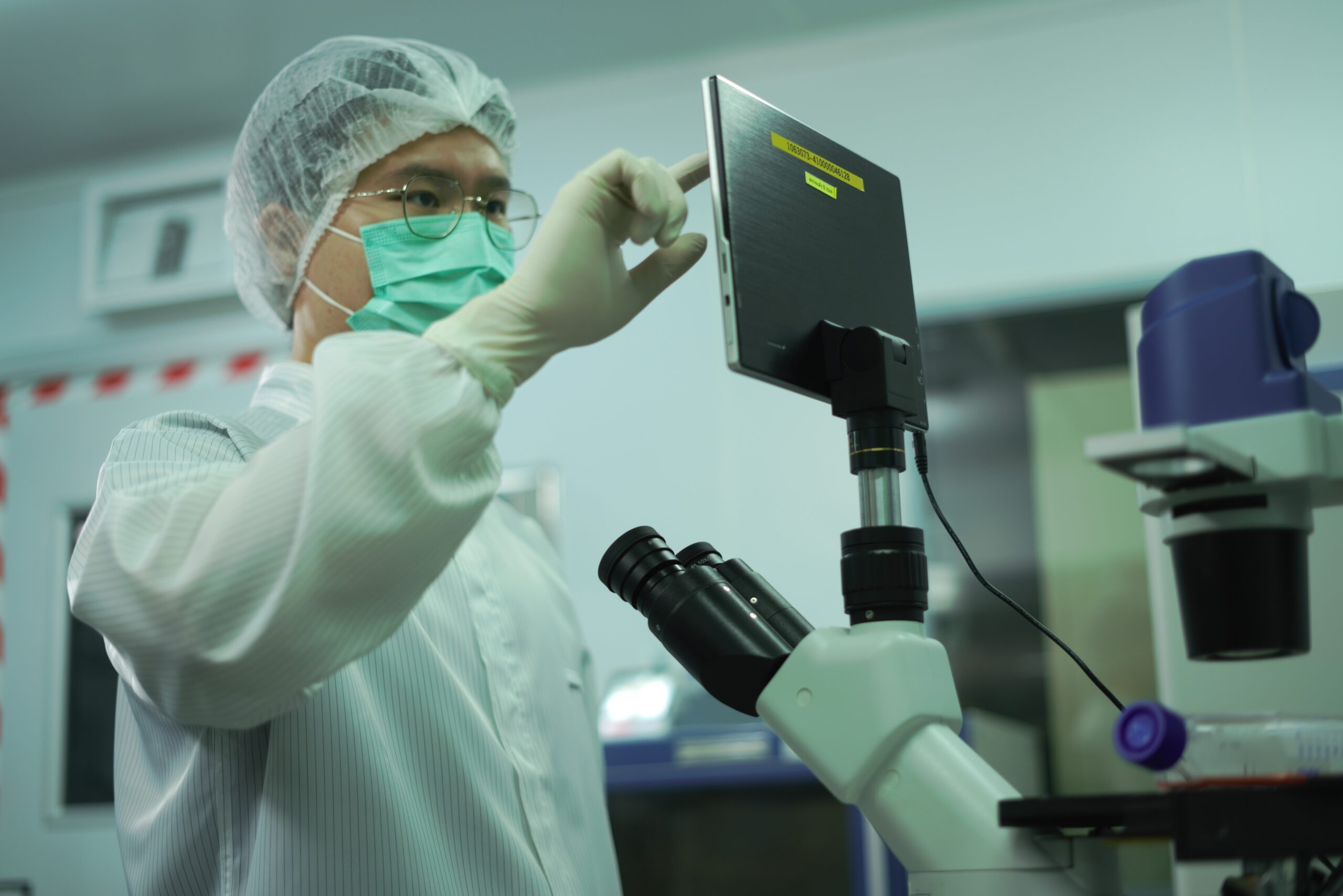 Man in lab coat using screen