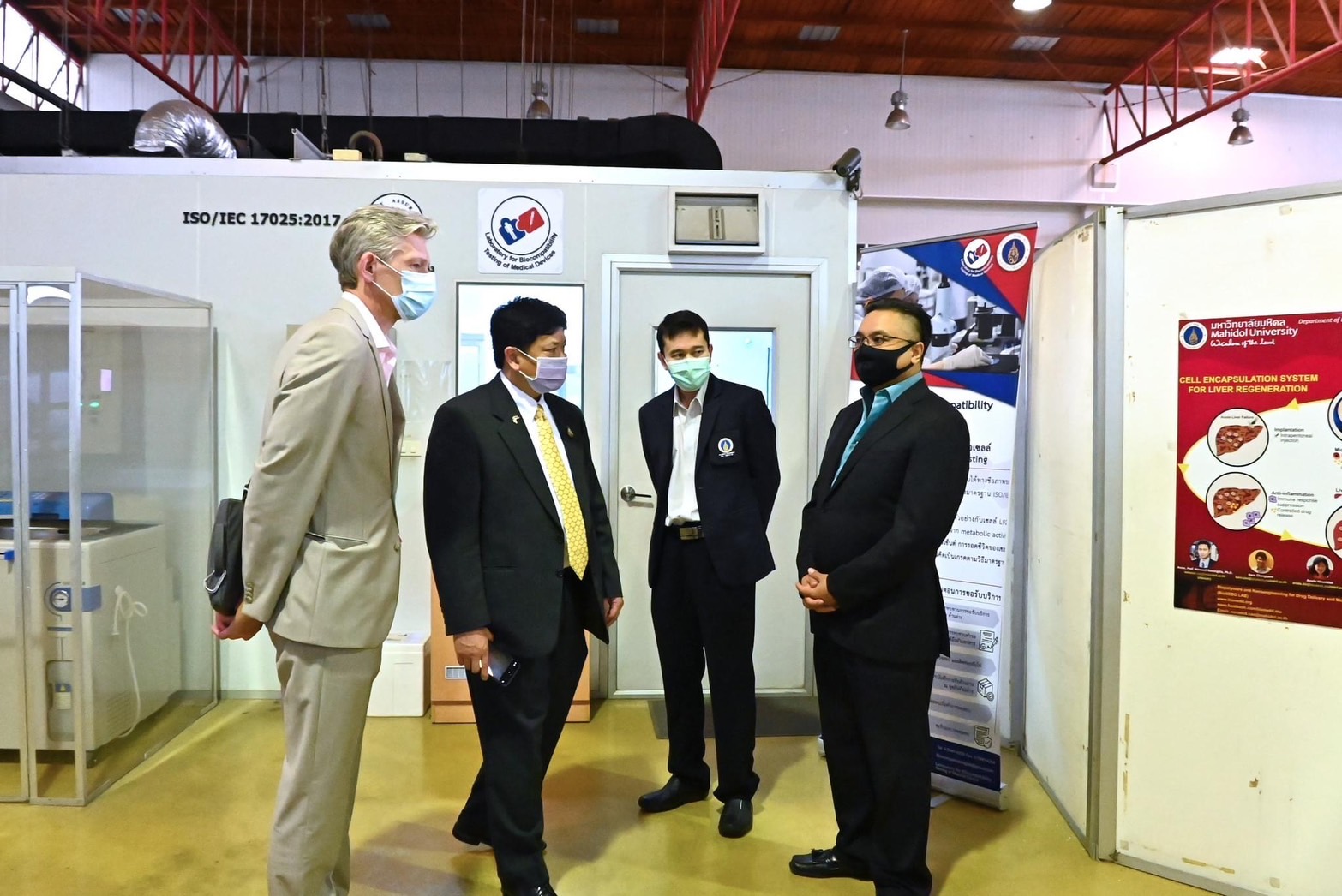 Men in suits discussed in front of a clean room